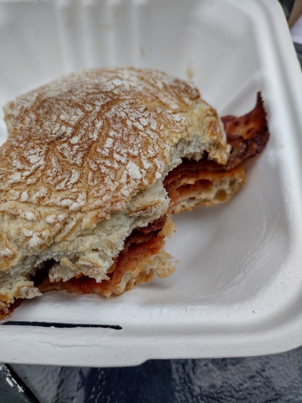A bacon sandwich in a takeaway box