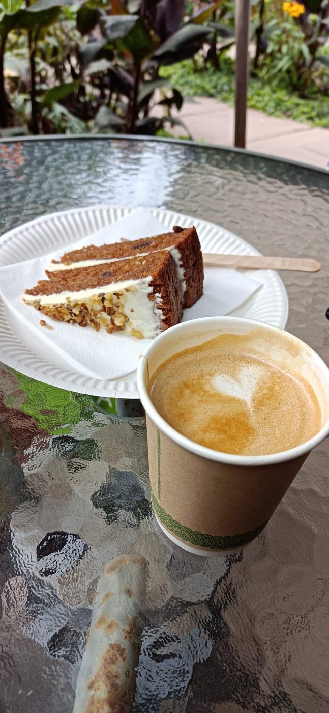 Carrot cake with a latte on a glass table